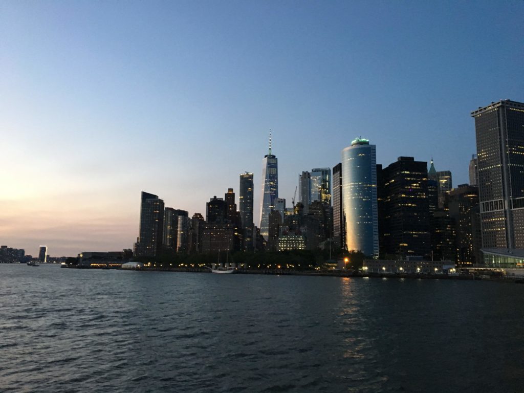 This is an image of the skyline of Lower Manhattan with One World Trade Center at sunset in New York City NYC.