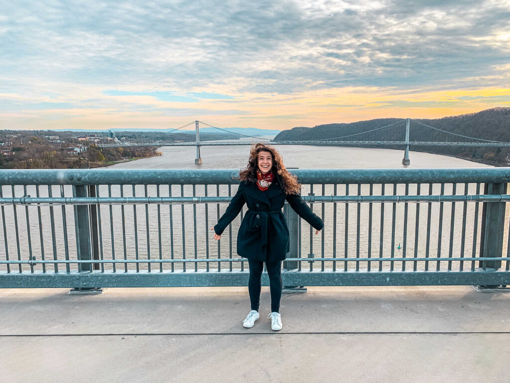 This is an image of a woman standing in the wind on the Walkway Over the Hudson in Poughkeepsie, NY.