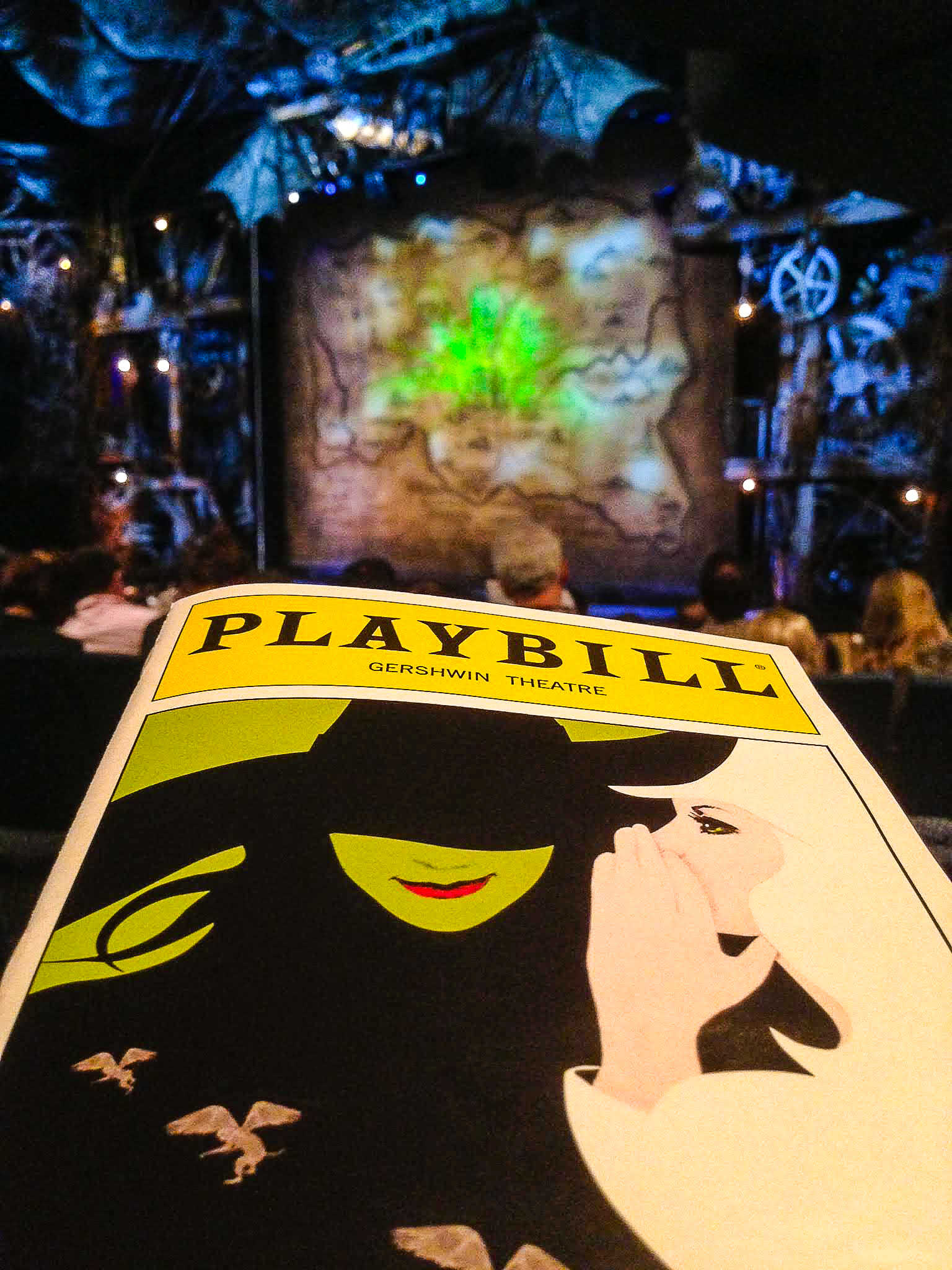 This is an image of the Broadway Playbill for Wicked in front of the stage at The Gershwin Theater in New York City - From big, bright classic American musicals to intimidate plays to more experimental works. New York theatre is one of a kind and worth experiencing, even just once. These are my best tips for attending a Broadway show and for how to buy Broadway tickets.