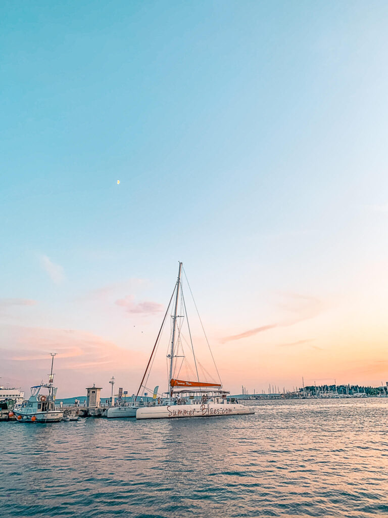 This is an image of a sailboat on the harbor in Split, Croatia at sunset.