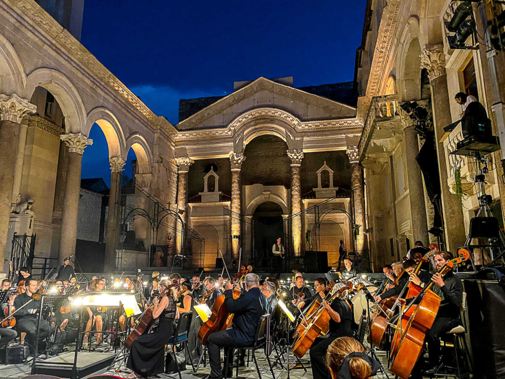 This is an image of the Peristyle in Split, Croatia at night with an orchestra set up to perform