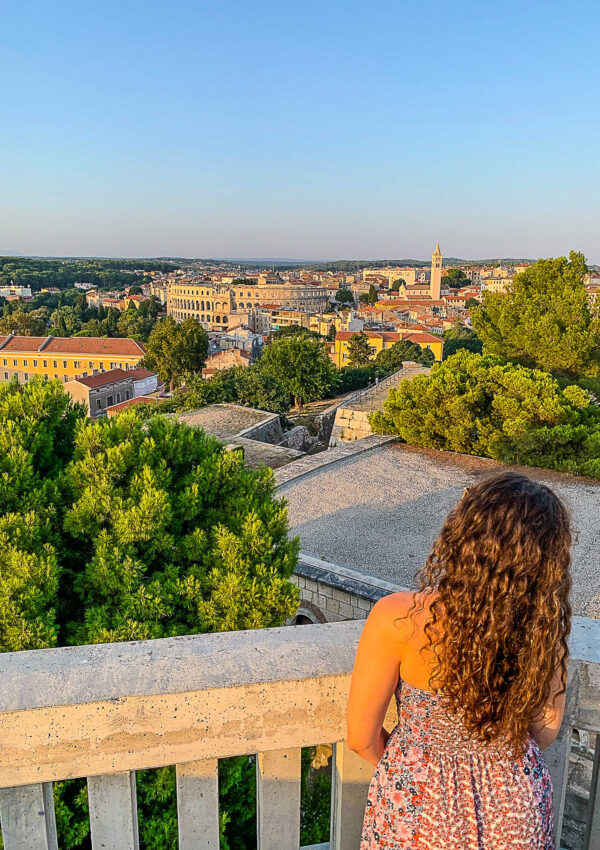 This is an image of a woman looking at the view of the Pula Arena in Pula, Croatia.