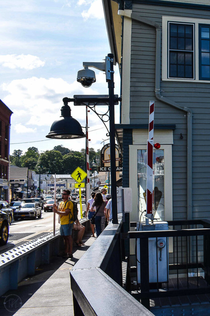 This is an image of downtown Mystic, Connecticut looking at the Mystic Drawbridge Ice Cream shop from the Mystic River Bascule Bridge on a sunny summer day.