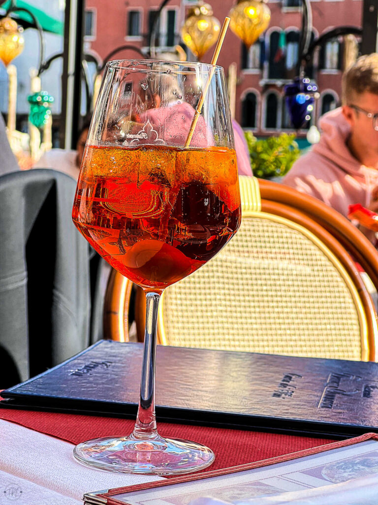 This is an image of an aperol spritz near the Grand Canal in Venice Italy.