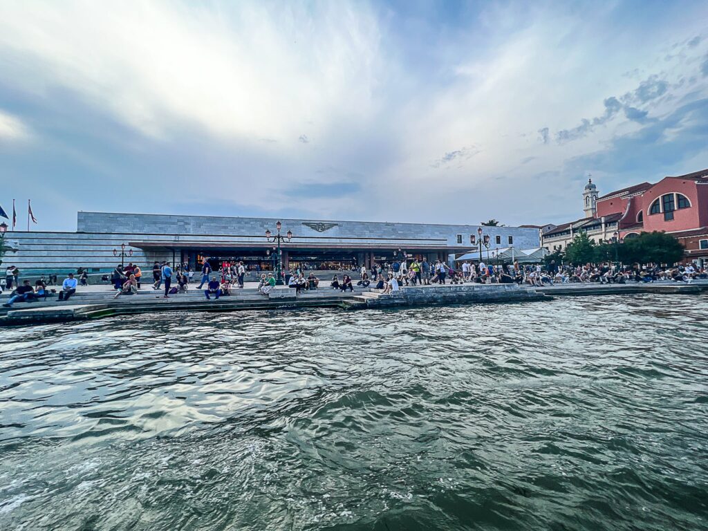 This is an image of the outside of the train station in Venice Italy from the canal.