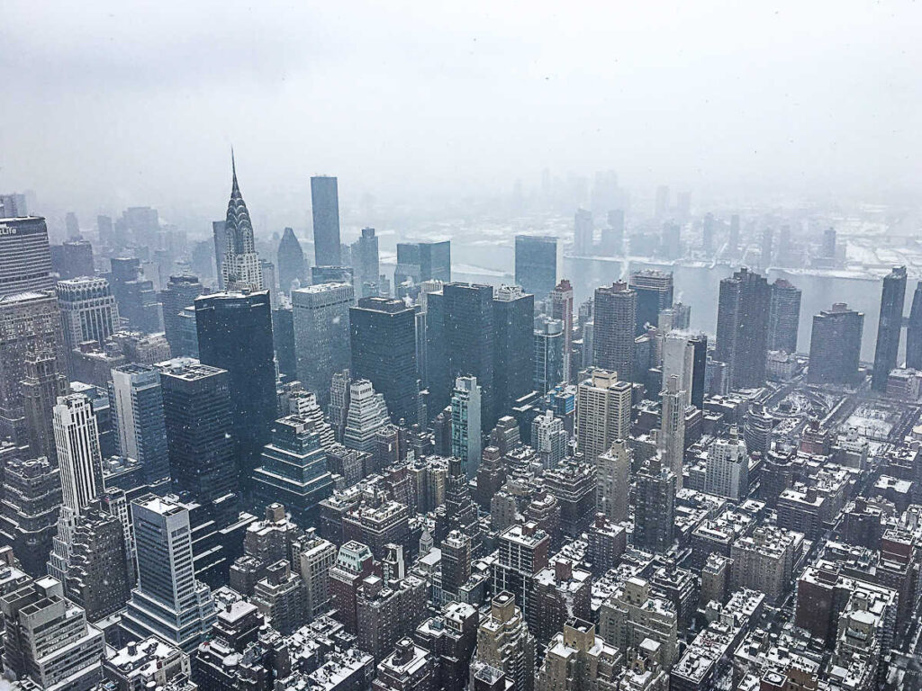 This is an image of the NYC skyline from the Empire State Building with snow in New York City.