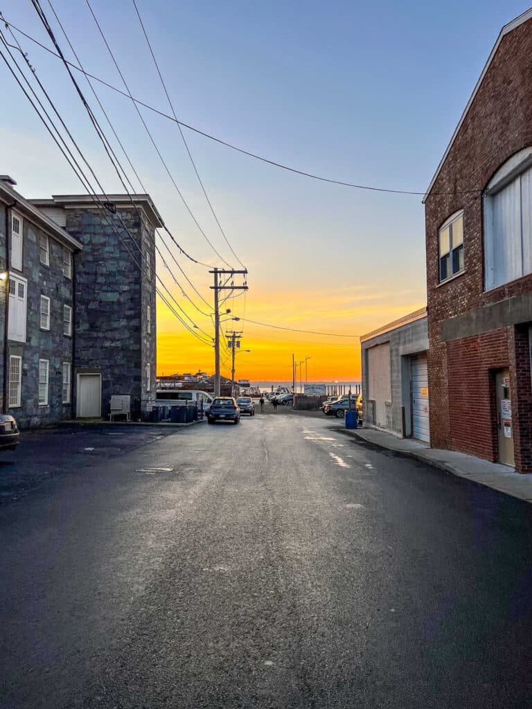 A serene street with parked cars and a building in the background, capturing the atmosphere of 3 days in Newport.